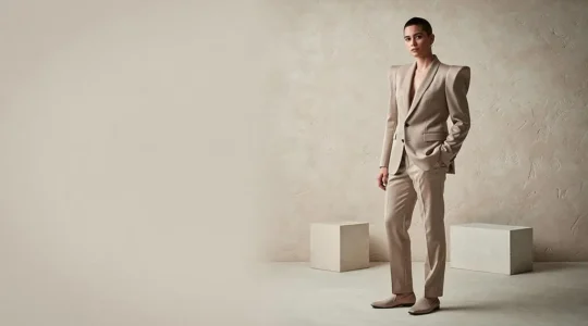 Persona con un blazer de hombros marcados combinado con básicos neutros, representando el equilibrio entre alta costura y moda accesible