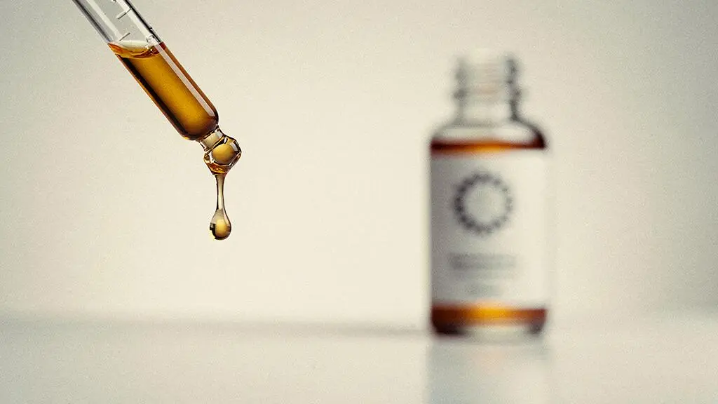 Gota de sérum facial cayendo de un cuentagotas de vidrio, simbolizando el análisis de la concentración real de activos