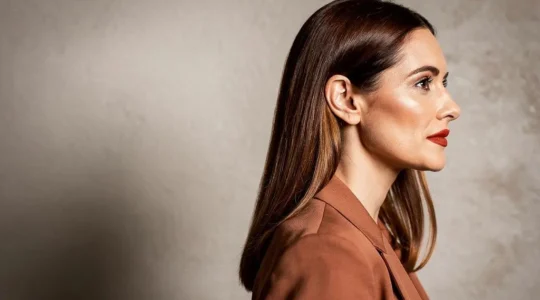 Mujer con un look editorial donde el color del blazer, el brillo del cabello y el tono del labial forman una paleta armónica y coherente