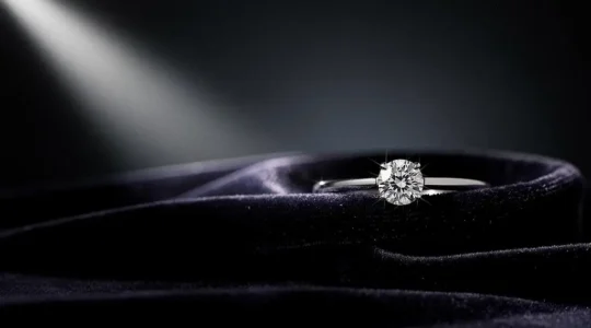 Anillo solitario de diamante brillando bajo una luz suave, simbolizando el máximo impacto visual dentro de un presupuesto cuidado
